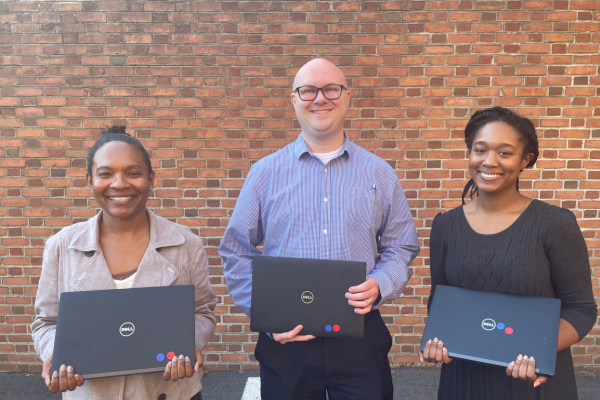 Executive Director of Client Services Mike Murphy (center) poses with Clarissa Blanco and Sidney Brooks the day they picked the laptop donations up to ship to Ghana. 