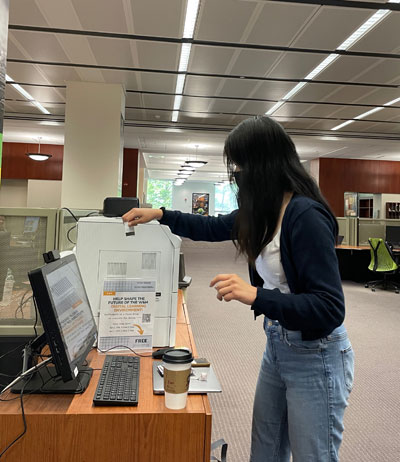 A student swipes their Tribe Card at one of the new lab printing stations