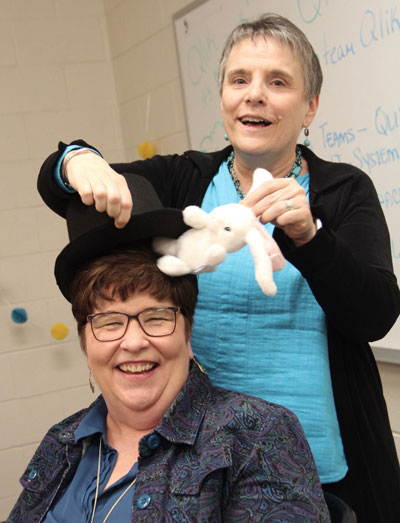 Berni Kenney pulls a rabbit from the hat of longtime colleague and friend Rachel Pace while celebrating the launch of Qlik, W&M's data discovery tool. The theme of the celebration was "magic" because they felt getting Qlik in place did and would continue to include some form of magic. 