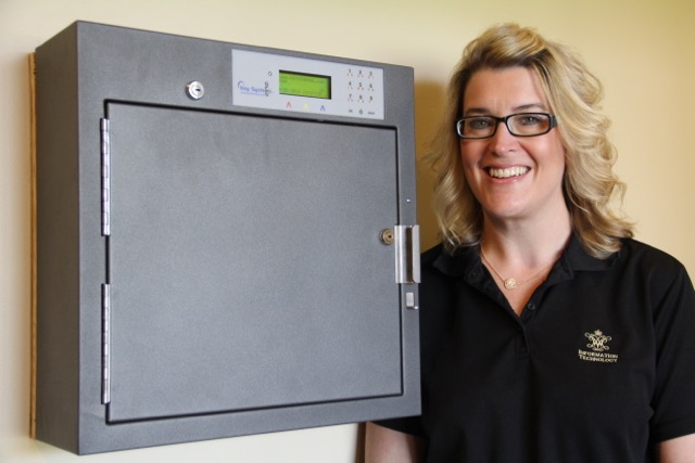 W&M IT's Melissa Marshall stands next to one of the 19 new key cabinets installed around campus. She is the application engineer for KeyBox and helped implement the system.