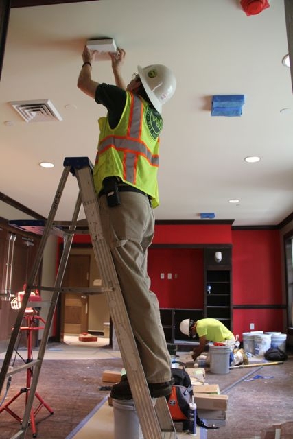 Jeff Jolly, Network Engineer, installs a wireless access point in a new fraternity building.