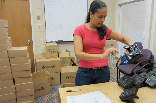 IT's Patty Herrera takes inventory of recently received ShoreTel phones.
