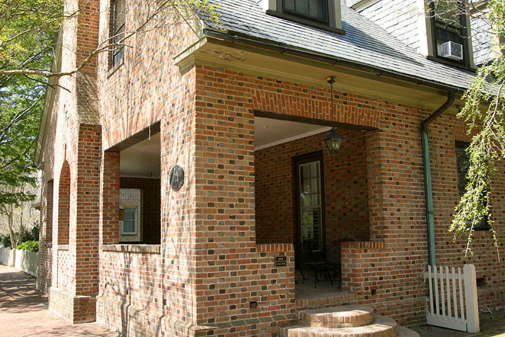 Brick house with dormer windows, slate roof and front porch