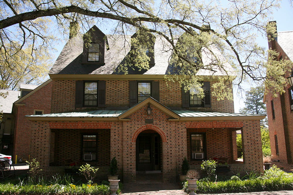 Brick house with dormer windows, slate and copper roof and front porch