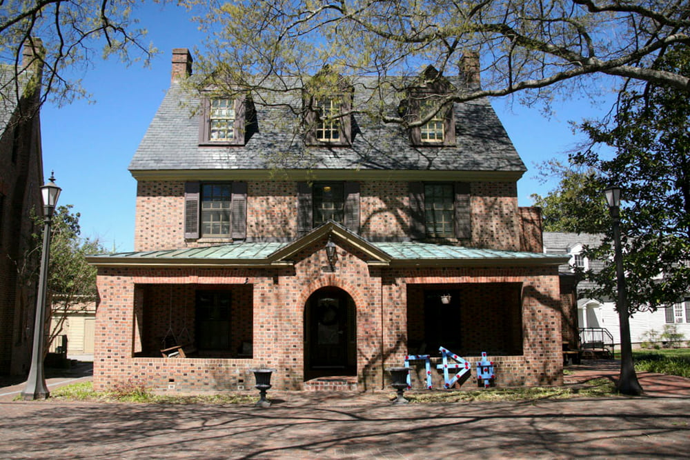 Brick house with dormer windows, slate and copper roof and front porch