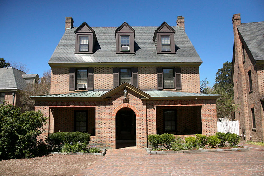 Brick house with dormer windows, slate and copper roof and front porch