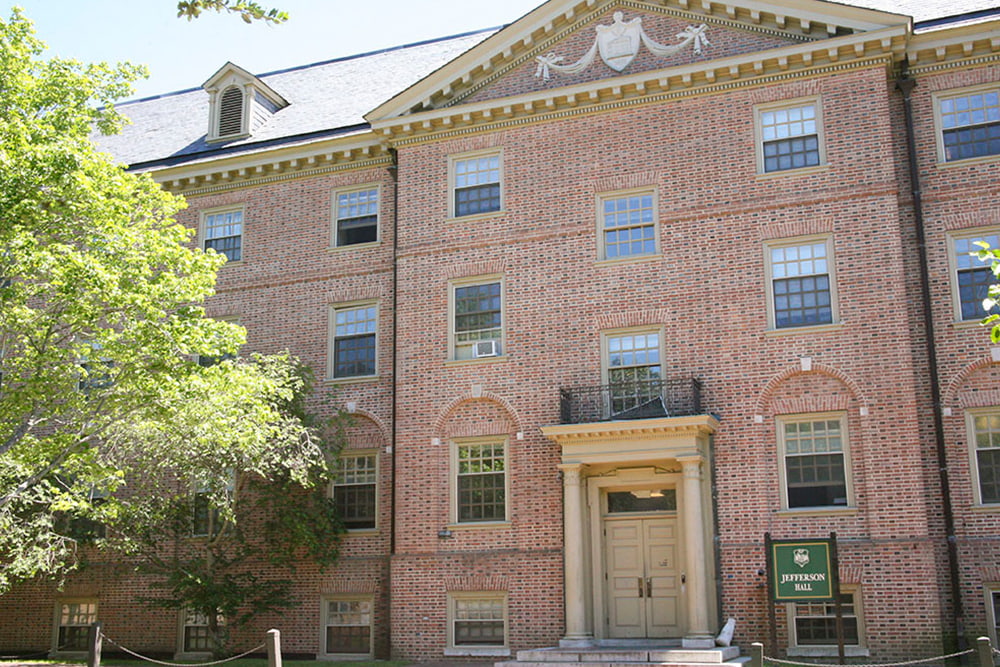 The entrance of a brick, windowed dorm building.
