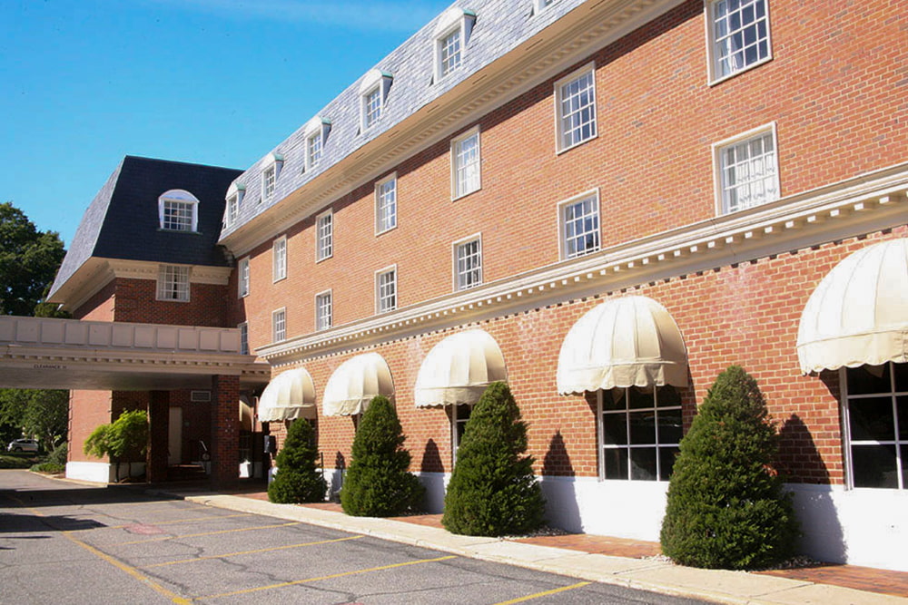 Brick dorm building next to a parking lot.