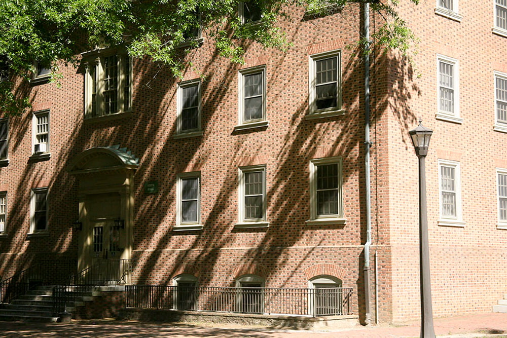 The entrance of a brick, windowed dorm building.