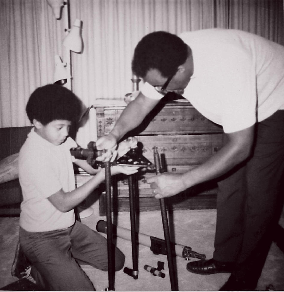 Tyson assembles the telescope he received on his 12th birthday, with help from his father, Cyril.(As printed in Columbia Magazine)