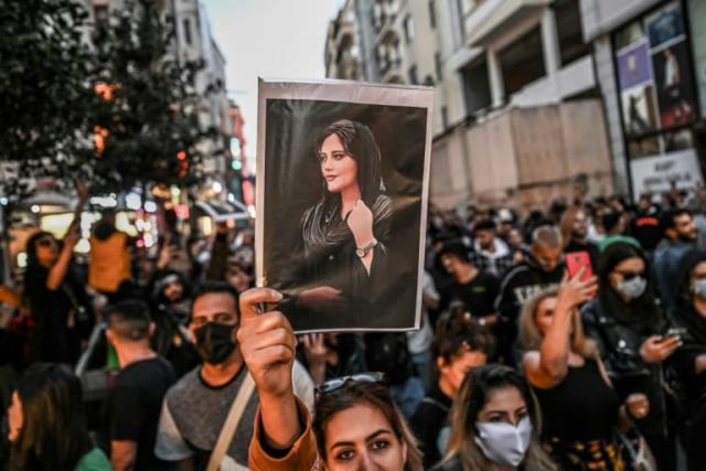 A protester holds a portrait of Mahsa Amini during a demonstration in support of Amini, a young Iranian woman who died after being arrested in Tehran by the Islamic Republic’s morality police, on Istiklal avenue in Istanbul on September 20, 2022. Ozan Kose | AFP | Getty Images