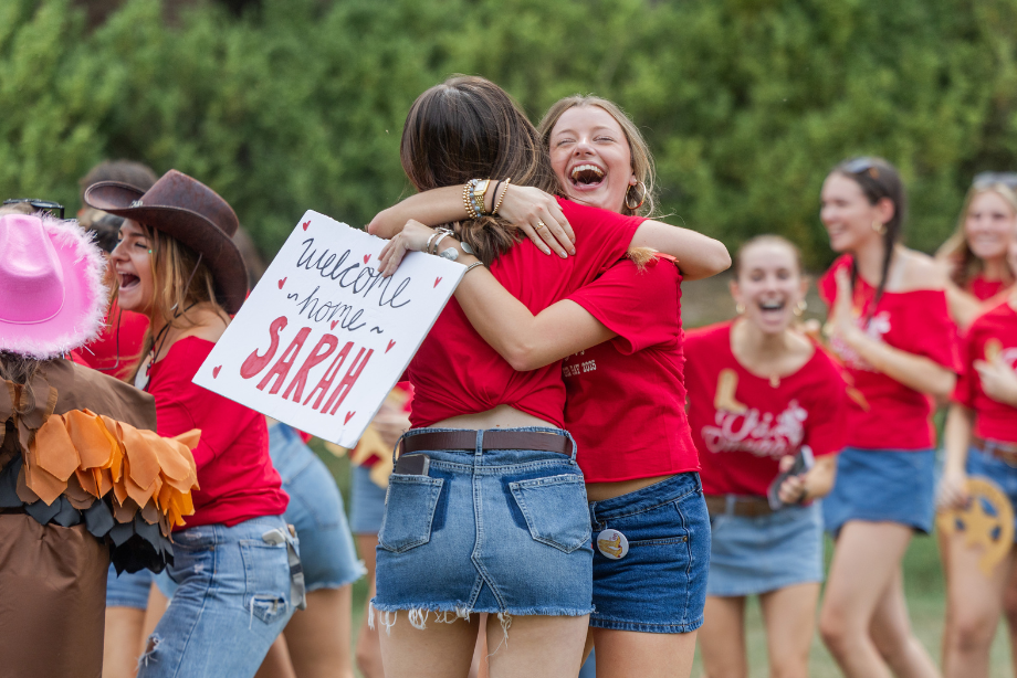 A recruitment counselor (RC) hugs her chapter sister on Bid Day, celebrating her return to her chapter after guiding potential new members through recruitment. (Photo by Katie Warner, courtesy of University Marketing)