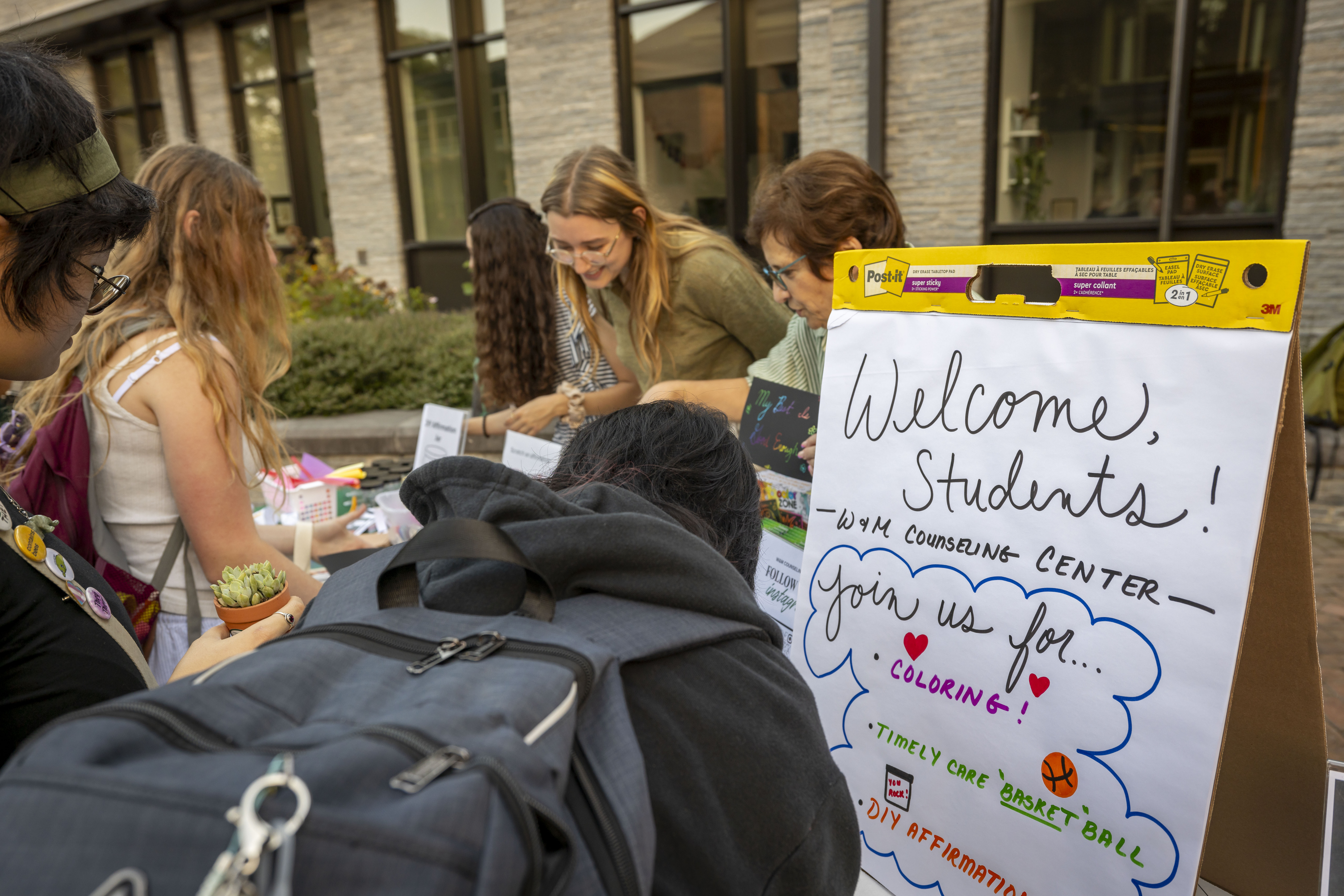 Carina Sudarsky-Gleiser, director of the Counseling Center, helps students craft DIY affirmations during the Student Life Neighborhood Block Party. (Photo by Timothy D. Sofranko, courtesy of University Marketing)