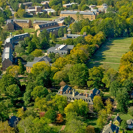 Aerial view of the William & Mary campus with brick academic buildings surrounded by trees and open green space.