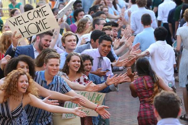Students energetically cheering to celebrate new students as they process through the Wren Courtyard.