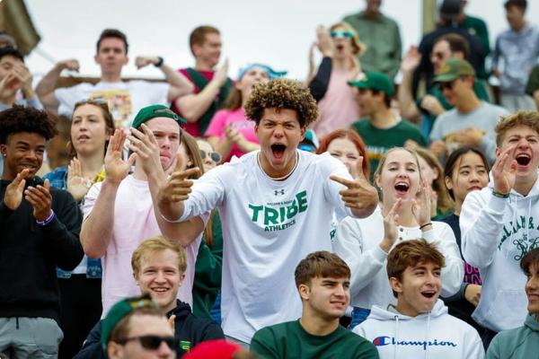 Students energetically cheering at a Tribe football game.