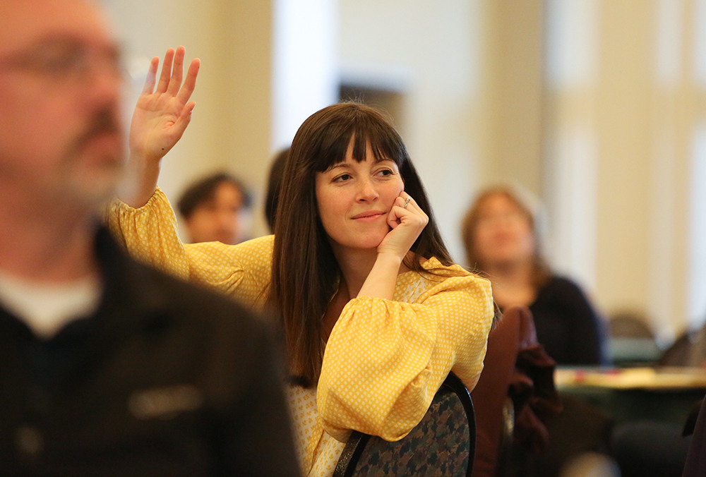 A William & Mary employee raises their hand at a staff function.