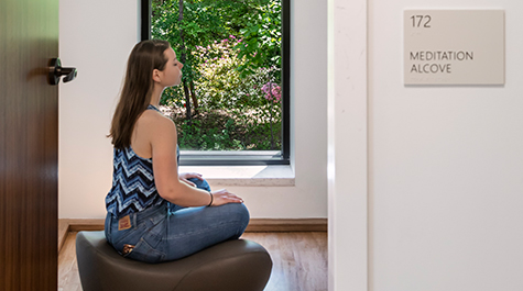 A student meditates in the meditation alcove. 