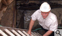 Dr. Bill Kelso enters the well that contained 400-year-old oyster shells and other archeological materials and artifacts.