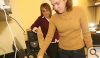 Carolyn Brown '09 (front) and Lisa Landino load a 96-well plate reader...