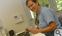 Caitlin Dronfield '10 uses a plastic spoon to take samples...