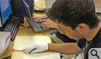Sharpe Seminar Program student Ian Garbarine '12 uses white gloves and a light touch to scan on of the recovered historic documents from the operations of the Independent Order of St. Luke.