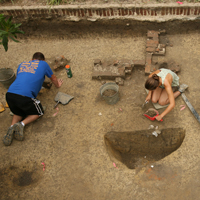 students digging in a pit by Brown Hall