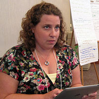 Lynsey LeMay checks the program agenda between presentations