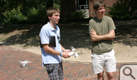 Reed Beverstock (left) and Daniel Duane talk out a flight plan to record the motion of the water spray from a rotating sprinkler at the sundial in front of Swem Library