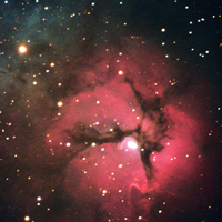 The red region is an area of ionized hydrogen where stars are forming and the blue region is a cloud of dust particles that reflect the light from nearby stars.