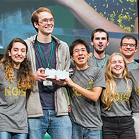 Members of the William & Mary team celebrate their win on the stage of the iGEM Grand Jamboree. 