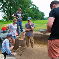Martin Gallivan (in cap) discusses how to best excavate a hearth feature with (from left) Madeline Gunter, Jessica Bittner and Megan Willmes ’16 as Jak Scrivener ’ 16 takes field notes.