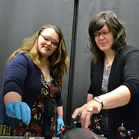 Shelle Butler (left) a graduate student in chemistry, adjusts optics for the SERS apparatus with her mentor, Kristin Wustholz.