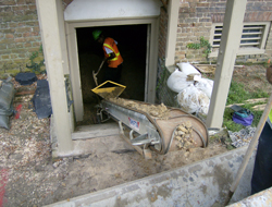 Construction workers remove dirt from the cellar of the Brafferton
