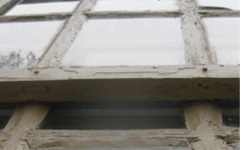 Paint peels from an exterior window of the Brafferton before its renewal is complete