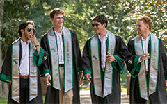 Four students walking together with cigars.