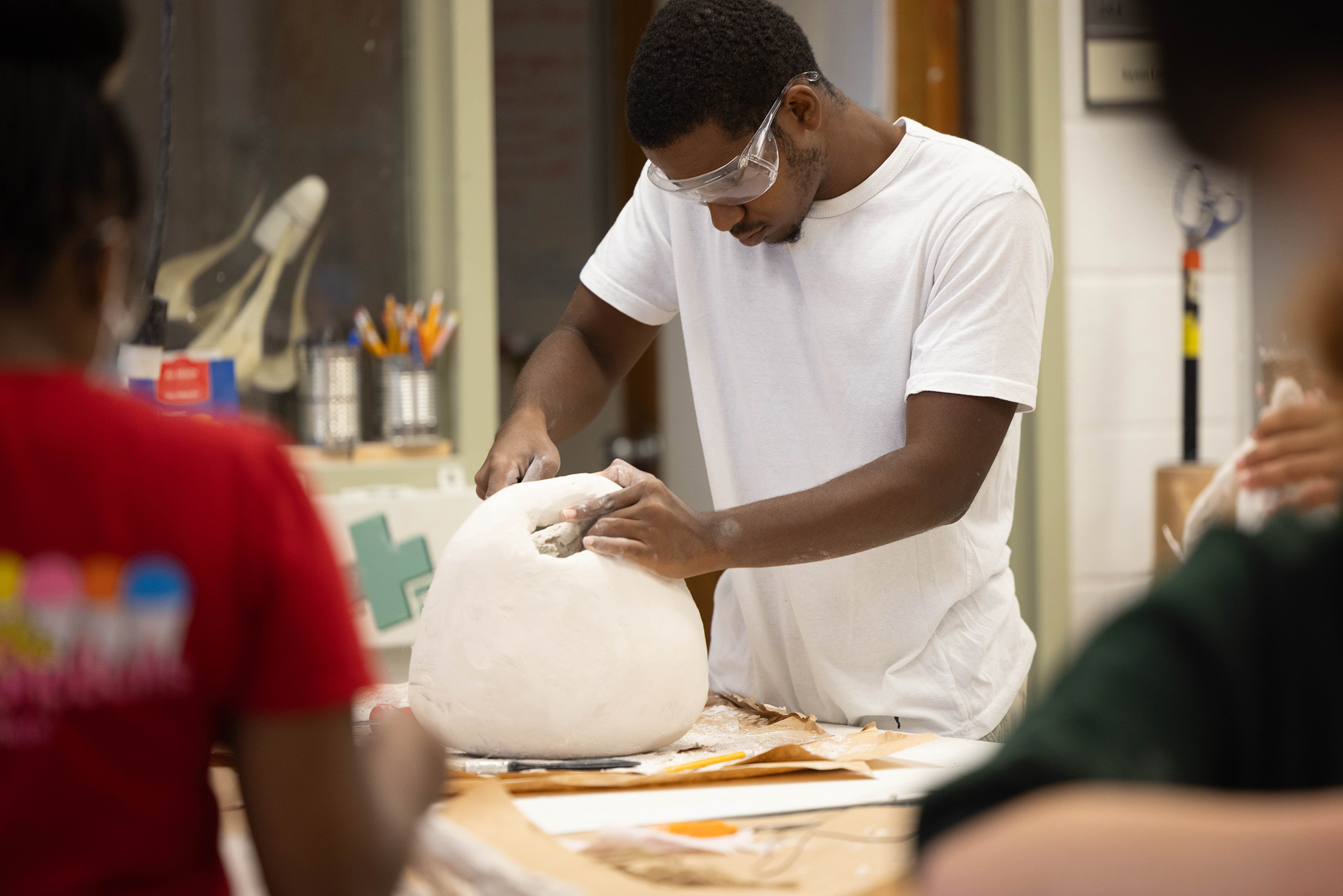 A student sculpts with clay