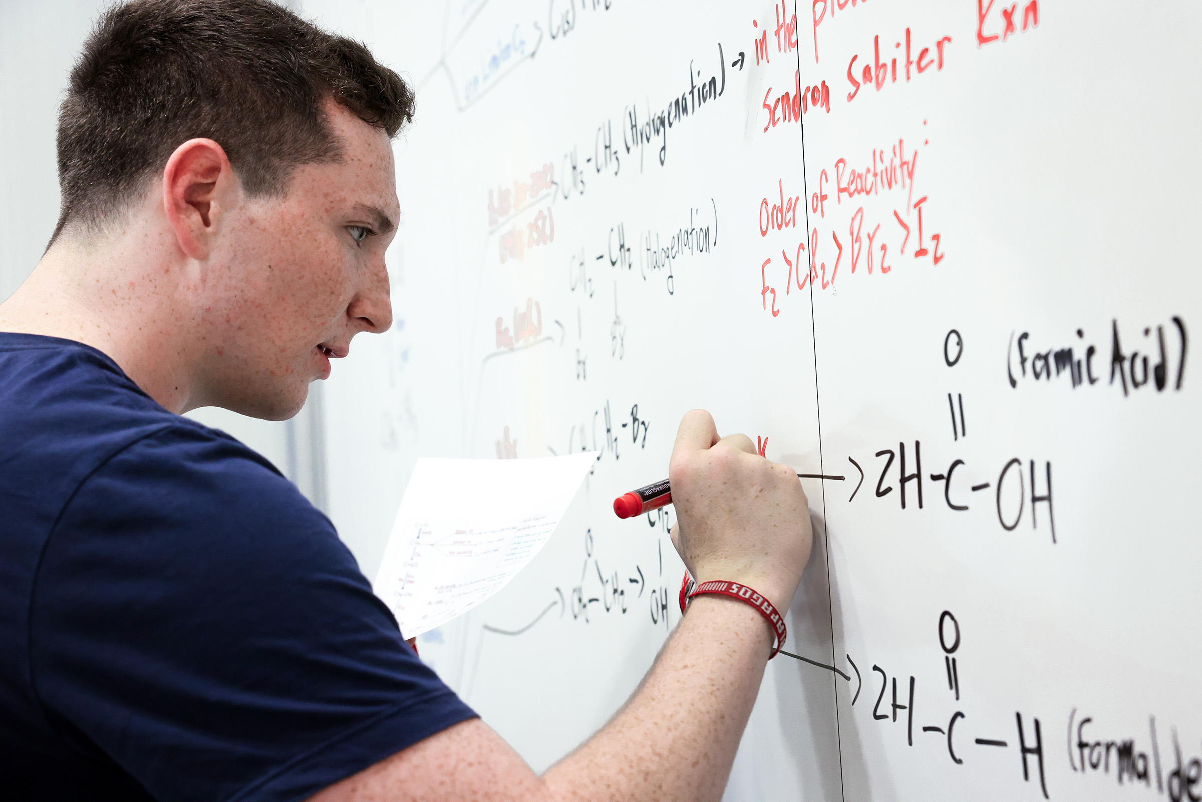 A student writes on a whiteboard
