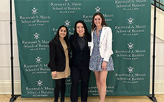Three students smiling in front of a W&M backdrop