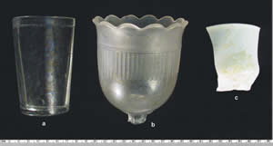 Some of the more complete tableware items include, from left, a tumbler, an ornate cut glass goblet, and a large piece of a whiteware cup.