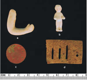 A porcelain doll's arm, a tiny ceramic doll. The coin is a Liberty nickel dating to 1909. The harmonica fragment is one of the four pieces recovered from the sites.