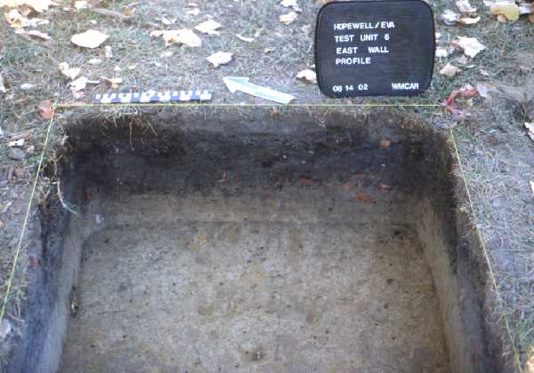 Profile of the wall of a test unit showing “strata” or natural levels of soil. Also note the broken pieces of brick visible in the right half of the profile.